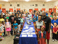 Large classroom with student families posing.